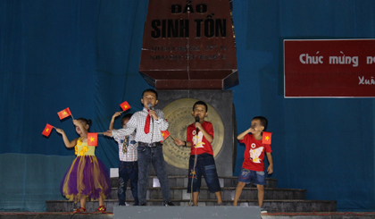 Trẻ em ở đảo Sinh Tồn biễu diễn văn nghệ bên cột mốc chủ quyền.