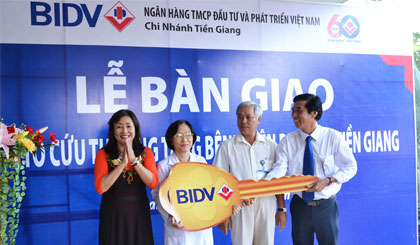 Ông Trần Văn Hòa, Giám đốc BIDV Tiền Giang (bên phải) trao bảng tượng trưng cho Ban Giám đốc Bệnh viện Phụ sản Tiền Giang.