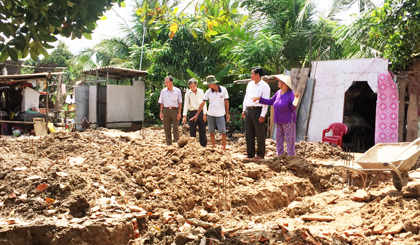 Bà Muốn (bìa phải) cùng đồng đội tham quan tiến độ xây nhà do Hội CCB tỉnh vận động xây cho bà.