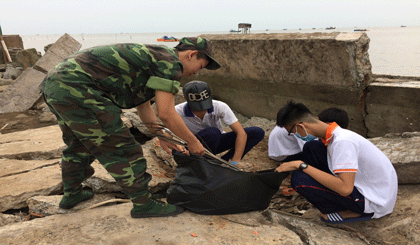 Chiến sĩ BĐBP và đoàn viên thanh niên tiến hành dọn vệ sinh, thu gom rác thải tại bãi biển Tân Thành