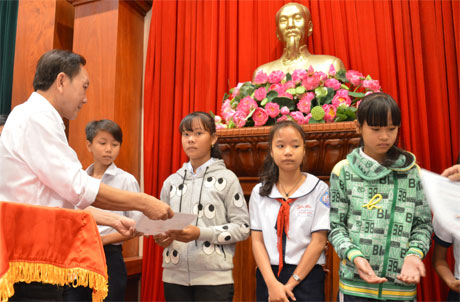 Ông Dương Ngọc Minh, Tổng Giám đốc công ty cổ phần Hùng Vương trao học bồng cho học sinh tại lễ trao học bổng Chắp cánh ước mơ lần thứ 10. Ảnh: Vân Anh