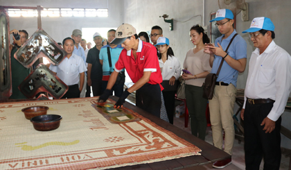 Đoàn khảo sát đang tham quan tìm hiểu về công đoạn in bông trong quy trình làm nên chiếc chiếu bông ở Làng nghề dệt chiếu Long Định.