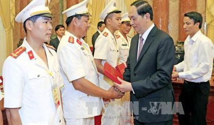 President Tran Dai Quang presents gifts to role-models of the police force at the meeting (credit: VNA)