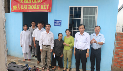 Các đại biểu và nhà tài trợ chụp ảnh lưu niệm cùng gia đình bà Đào Thị Hạnh bên căn nhà mới.