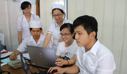 Điều dưỡng Nguyễn Thị Mỹ Linh (đứng giữa) trao đổi nghiệp vụ với các đồng nghiệp ở Bệnh viện Đa khoa khu vực Cai Lậy.                                             Ảnh: HỮU NGHỊ