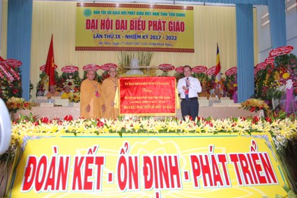 Phó Chủ tịch UBND tỉnh trao bức trướng của UBND tỉnh đến đại diện Ban Trị sự Phật giáo tỉnh.