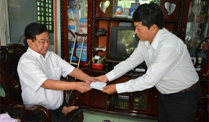 Ông Trần Vĩnh Hưng, giám đốc Sở Lao động Thương binh và Xã hội tặng quà Thương Binh Bùi Văn Mẫm