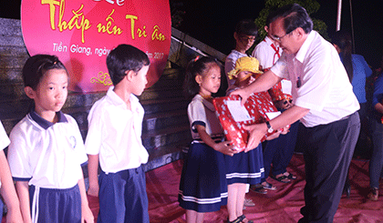 Ông Võ Văn Bình trao quà cho 10 học sinh là con em gia đình chính sách xã Trung An, TP. Mỹ Tho.