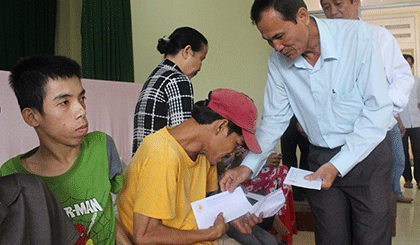 Ông Lê Văn Hùng, Phó Chánh Văn phòng HĐND tỉnh tặng quà cho các nạn nhân nhiễm chất độc da cam/dioxin huyện Chợ Gạo