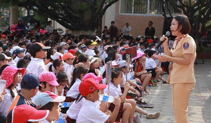 A policewoman discusses traffic safety with primary school students in Hanoi. (Photo: VNA)