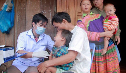 A medical worker gives vaccination to a child of a family mirgating to Lam Dong province (Photo: VNA)