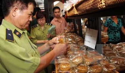 Inspectors check moon cake quality at a shop (Photo: VNA)