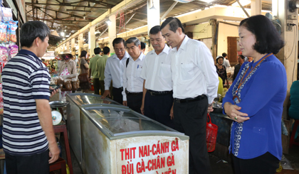 Chairman of the PPC checks a frozen meat stall at the market of Go Cong town. Photo: HUU NGHI
