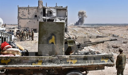 Binh sỹ Syria giao tranh với phiến quân IS tại khu vực ngoại ô phía bắc tỉnh Deir al-Zour ngày 14/9. Nguồn: AFP/TTXVN