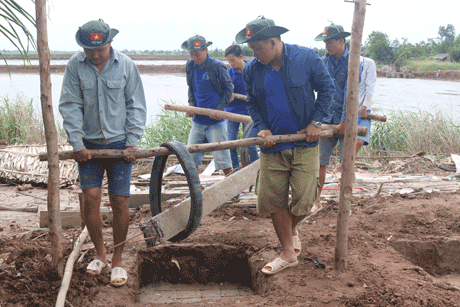 Chung tay thực hiện công trình xây dựng nhà đại đoàn kết cho người dân xã Phú Tân, huyện Tân Phú Đông.                                                                        Ảnh: PHAN LÂM