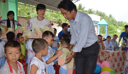 Ông Phạm Văn Sơn, Phó Tổng Biên tập Báo Ấp Bắc trao quà trẻ em.