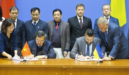 The two delegation heads sign the minutes of the meeting.