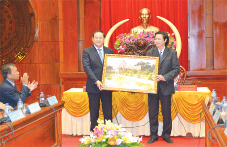 Member of Central Party Committee, Secretary of the Tien Giang provincial Party Committee, Chairman of the Provincial People's Council Nguyen Van Danh (R) presents souvenir to Lao Deputy Prime Minister Sonexay Siphandone (L). Photo: THU HOAI