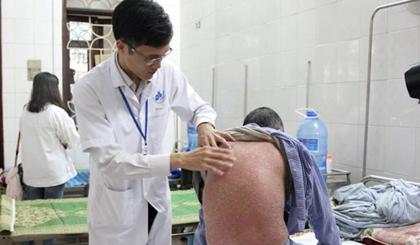 Bác sỹ khám cho một bệnh nhân bị bệnh vảy nến. (Ảnh: PV/Vietnam+)