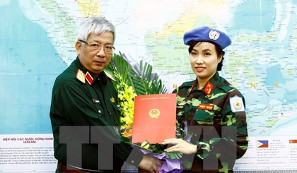 Deputy Minister of National Defence Senior Lieutenant General Nguyen Chi Vinh (L) hands over to Major Do Thi Hang Nga a decision sending her to UN peacekeeping mission in South Sudan (Photo: VNA)