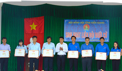 Đồng chí Nguyễn Quang Minh (đứng giữa) trao bằng khen của Hội đồng Đội Trung ương cho ho các tập thể và cá nhân hoàn thành xuất sắc nhiệm vụ công tác Đội và phong trào thiếu nhi năm học 2016 - 2017.