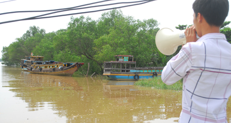 Trưởng ấp Gảnh (xã Phú Đông, huyện Tân Phú Đông) Nguyễn Hoàng Nghĩa dùng loa kêu gọi tàu thuyền vào nơi neo đậu an toàn.