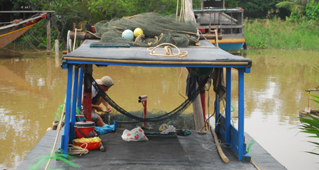 Ngư dân huyện Tân Phú Đông chuẩn bị lưới để ra khơi đánh bắt.