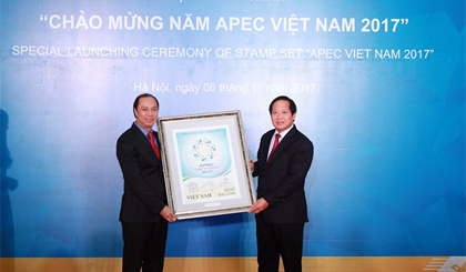 Bộ trưởng Trương Minh Tuấn (phải) tặng tranh Tem APEC cho Thứ trưởng Bộ Ngoại giao Nguyễn Quốc Dũng. Ảnh: VNPost