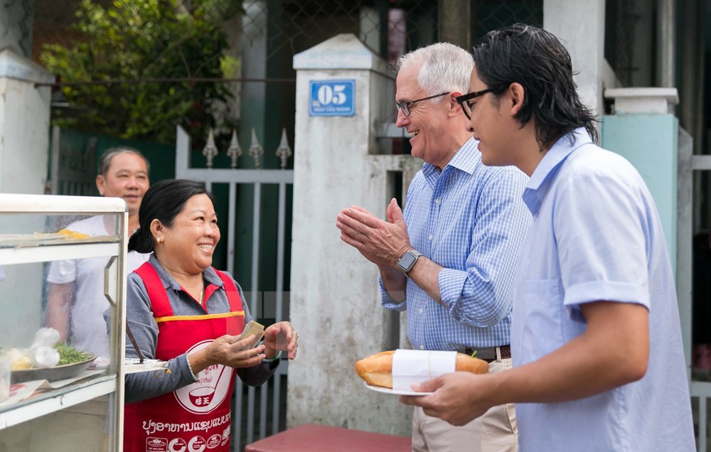 Thủ tướng Australia Malcolm Turnbull cùng đầu bếp người Australia gốc Việt Luke Nguyen ăn sáng với món bánh mỳ tại một cửa hàng ở thành phố Đà Nẵng. (Nguồn: TTXVN)