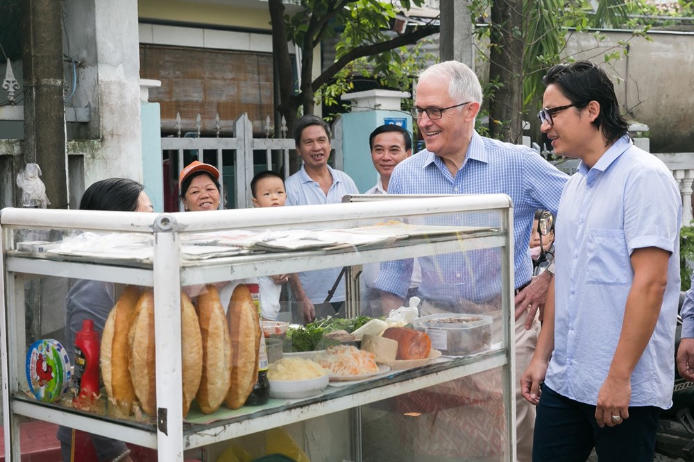 Thủ tướng Australia Malcolm Turnbull cùng đầu bếp người Australia gốc Việt Luke Nguyen ăn sáng với món bánh mỳ tại một cửa hàng ở thành phố Đà Nẵng. (Nguồn: TTXVN)