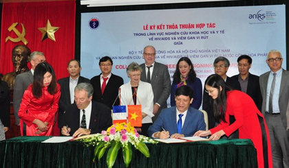 Đại diện Bộ Y tế và ANRS ký kết Biên bản thỏa thuận hợp tác. (Ảnh: PV/Vietnam+)