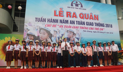 Đồng chí Lê Văn Hưởng trao nón bảo hiểm cho các em học sinh.