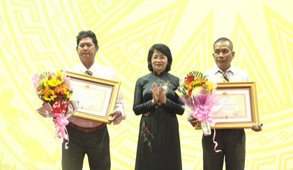 Vice President Dang Thi Ngoc Thinh awards the first-class Independence Medal to two martyrs' families. Photo; HANH NGA
