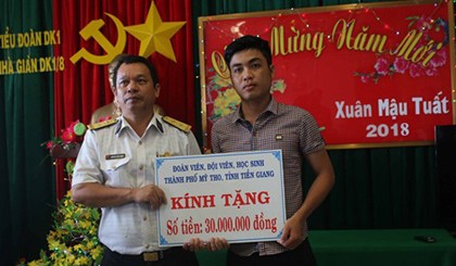 Phóng viên Minh Thành (Báo Ấp Bắc) trao quà Tết Nguyên đán Mậu Tuất 2018 của Thành đoàn  Mỹ Tho tặng cán bộ, chiến sĩ Nhà giàn DK1 (tỉnh Bà Rịa - Vũng Tàu).