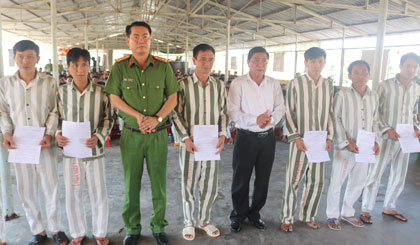 Thượng tá Võ Nhựt Hải và Chánh án TAND tỉnh Trần Ngọc Quang trao quyết định giảm án phạt tù cho các phạm nhân được tha tù trước thời hạn.