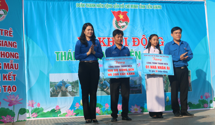 Chị Nguyễn Thị Uyên Trang, Bí thư Tỉnh đoàn (bìa trái) cùng anh Ngô Huỳnh Quang Thái, Phó Bí thư Tỉnh đoàn (bìa phải) trao bảng trượng trưng 1 ngôi nhà Nhân ái và 100 bộ bóng đèn cho ĐV-TN xã Tân Lập 2.