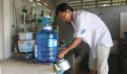 Do không có nước sạch, anh Phạm Văn Khá phải sử dụng nước suối đóng bình để nấu nướng rất tốn kém.