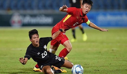 Vietnam's Vu Tien Long (in red) fight for the ball with a Thai player.