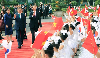 Presidents Tran Dai Quang and Moon Jae-in wave at Vietnamese children at the official welcome ceremony in Hanoi on March 23 morning (Photo: VNA)