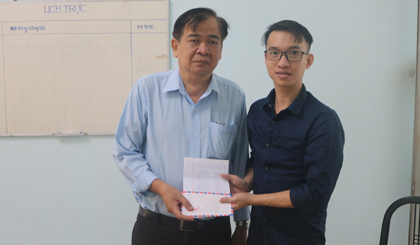 Tổng Biên tập Báo Ấp Bắc Nguyễn Minh Tân (bên trái) nhận số tiền hỗ trợ gia đình các nạn nhân vụ hỏa hoạn chung cư Carina Plaza từ đại diện CLB Hội Người điếc tỉnh Tiền Giang.