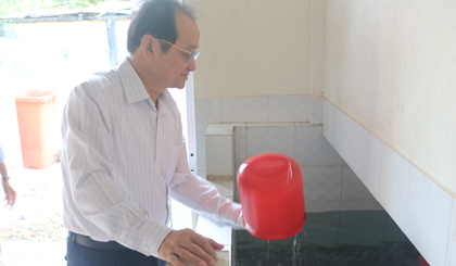Đồng chí Trần Thanh Đức kiểm tra hồ chứa nước của Khu vệ sinh Trường Tiểu học Mỹ Phước.