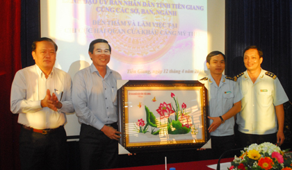 Chairman of the PPC Le Van Huong presents gifts of the PPC to the representative of the Customs Department in the My Tho Port. Photo: S.N