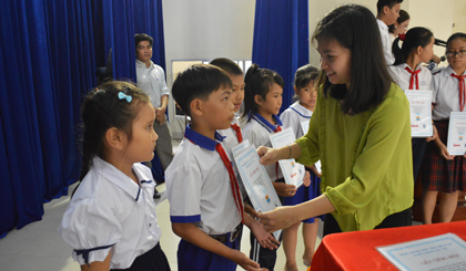 Bà Lê Kim Phụng - Phó Tổng Giám đốc Công ty Cổ phần Hùng Vương phát học bổng cho các em học sinh 