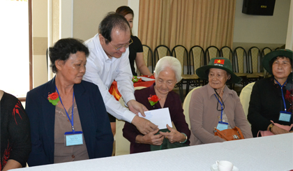Phó Chủ tịch UBND tỉnh Trần Thanh Đức cài hoa và trao quà cho người có công trước chuyến tham quan.