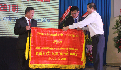 Phó Bí thư Tỉnh ủy, Chủ tịch UBND tỉnh Lê Văn Hưởng trao Cờ truyền thống của UBND tỉnh cho huyện Tân Phú Đông.