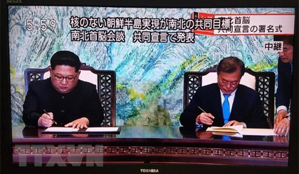 Nhà lãnh đạo Triều Tiên Kim Jong-un (trái) và Tổng thống Hàn Quốc Moon Jae-in ký tuyên bố chung tại Hội nghị thượng đỉnh liên Triều ở làng đình chiến Panmunjom ngày 27-4. Nguồn: Yonhap/TTXVN
