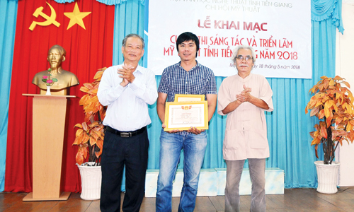 Deputy Director of the Department of Culture, Sports and Tourism Tran Thanh Phuc (left) and artist Ca Le Thang presented Le Nhat for Le Duy.