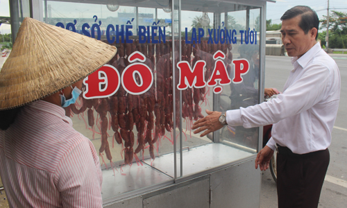 Chủ tịch UBND tỉnh Lê Văn Hưởng nhắc nhở người bán lạp xưởng tại khu vực gần trạm thu phí BOT Cai Lậy đảm bảo an toàn vệ sinh thực phẩm.
