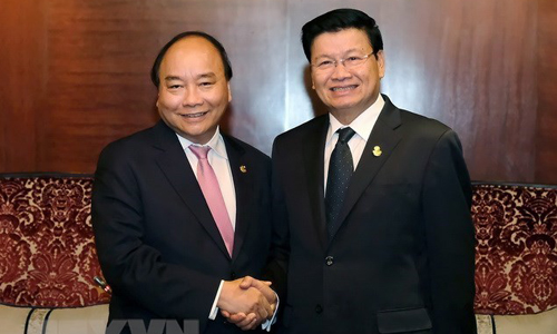 Prime Minister Nguyen Xuan Phuc (L) shakes hands with his Lao counterpart Thongloun Sisoulith (Photo: VNA)