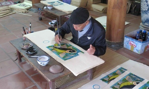  Artisan Nguyen Dang Che finishes a Dong Ho painting called Ca Chep Trong Trang (Moonlight Carp) (Photo: VNA)